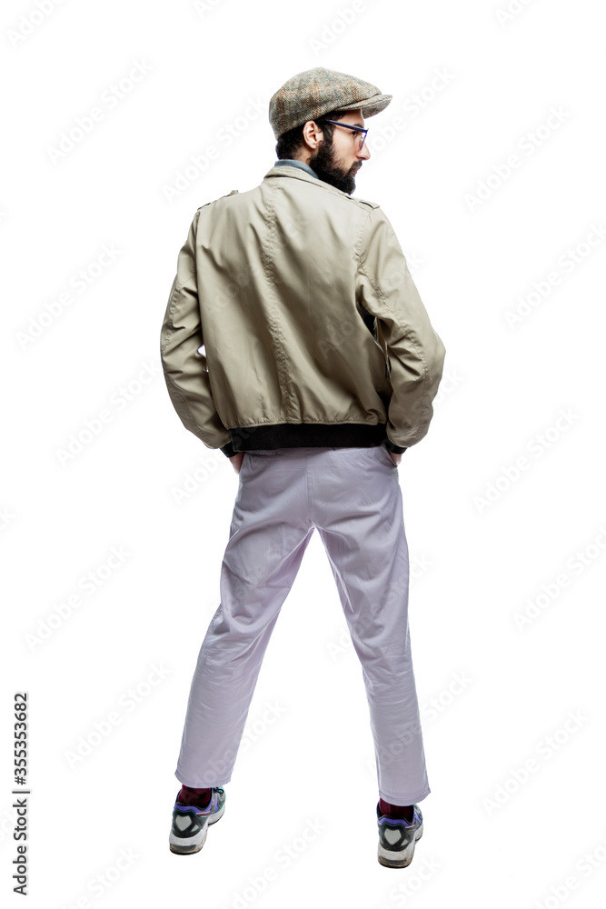 Stylish young man in glasses, with a beard and a cap. Back view. Isolated on a white background. Vertical. Stylish young man in glasses, with a beard and a cap. Back view. Isolated on a white background. Vertical.