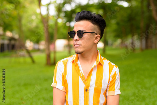 Young handsome multi ethnic man wearing sunglasses at the park outdoors © Ranta Images