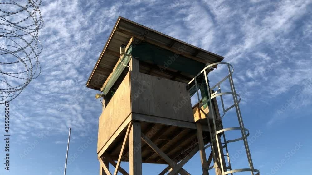 concept shot of wooden military watchtower on low angle against blue sky environment with white cirrus clouds and no people. Army border protection or war prison and confinement. concept shot of wooden military watchtower on low angle against blue sky environment with white cirrus clouds and no people. Army border protection or war prison and confinement.