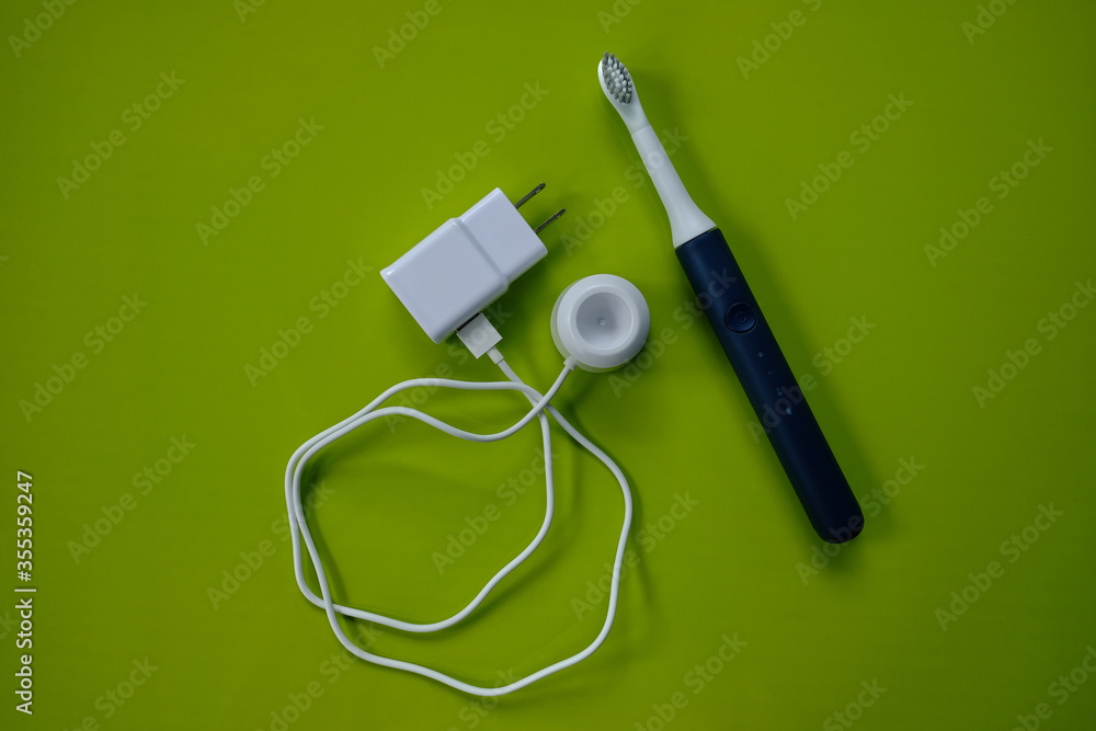 Electric toothbrush and USB charging dock on green. Electric toothbrush and USB charging dock on green.