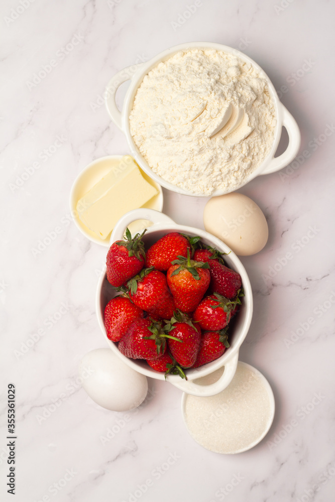 ingredients for baking strawberry muffins top view. ingredients for baking strawberry muffins top view.