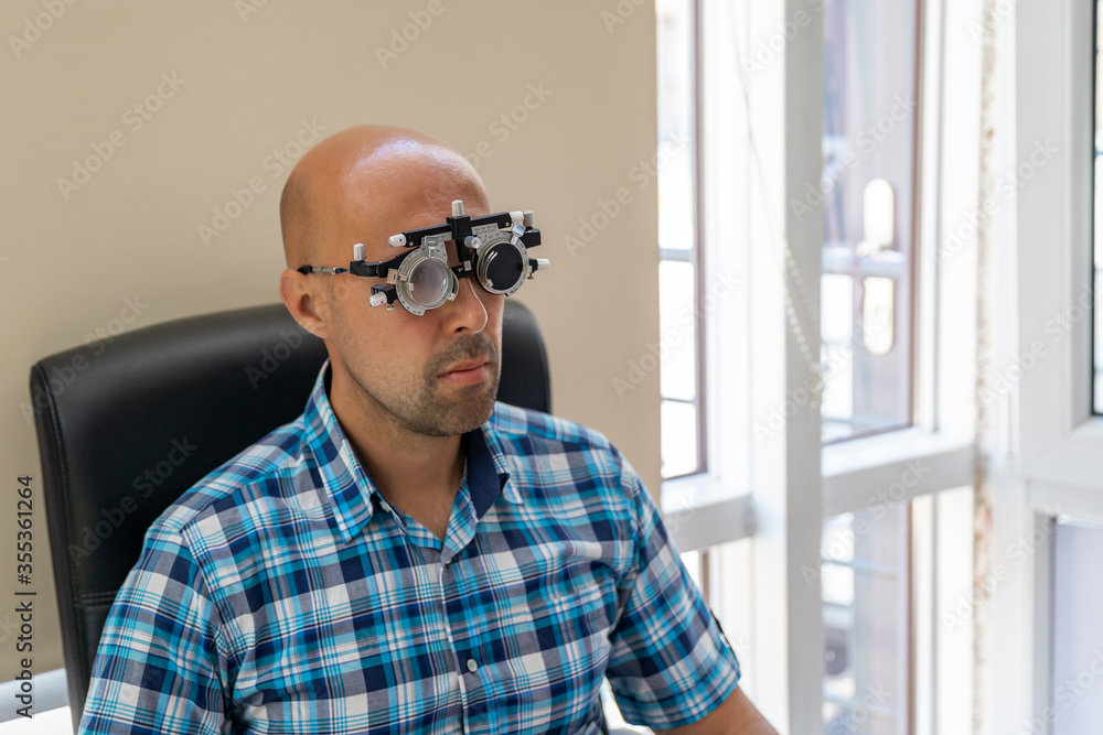 vision measurement by optometrist at clinic, young man as patient vision measurement by optometrist at clinic, young man as patient