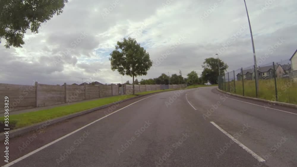 POV shot of road by residential buildings in town against cloudy sky - Galway, Ireland POV shot of road by residential buildings in town against cloudy sky - Galway, Ireland