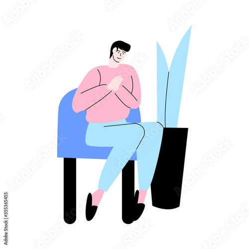 Young man sitting on armchair and feeling happy at home during weekday