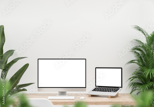 Computer and laptop blank screen on wood table decorated with indoor plants. 3D illustration