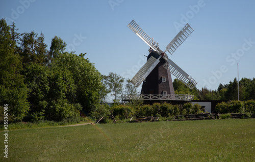 Old windmill with green grass and blue sky © mariahvid