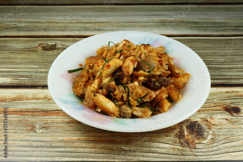 Spicy fried fish with chilly paste, basil and local sauce in Thai style on the plate. Famous hot and spicy menu in Asia. Traditional appetizer food in ancient party. 