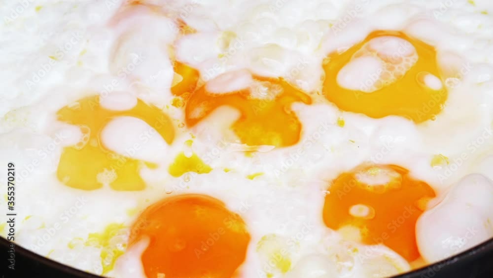 Closeup dolly shot of the eggs frying in a pan on a kitchen stove, taken with a macro lens in UHD Closeup dolly shot of the eggs frying in a pan on a kitchen stove, taken with a macro lens in UHD