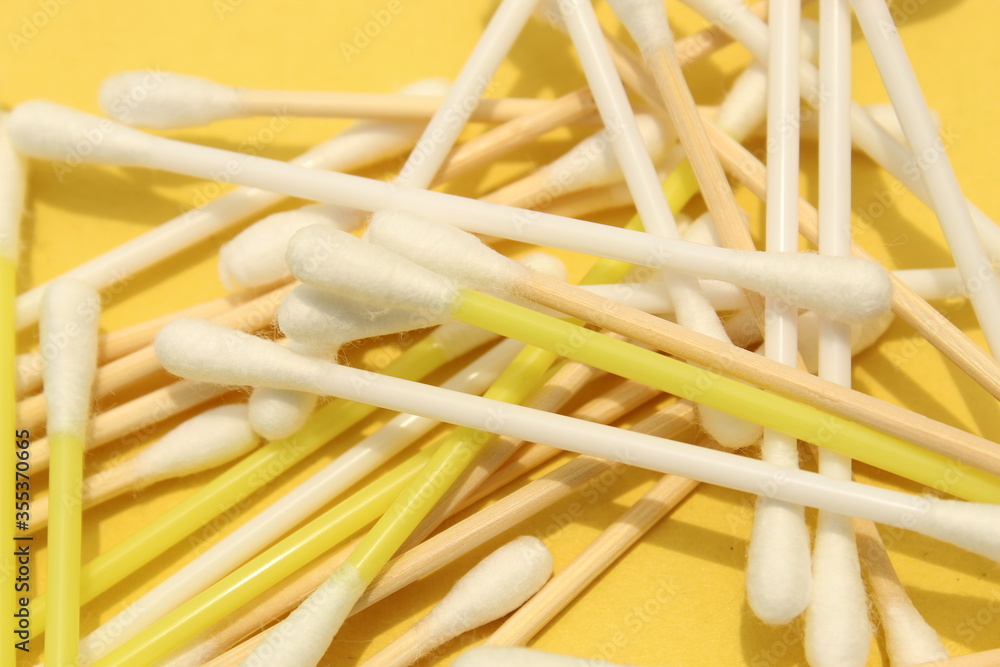 Cotton made ear buds all together close display on yellow background. Cotton made ear buds all together close display on yellow background.