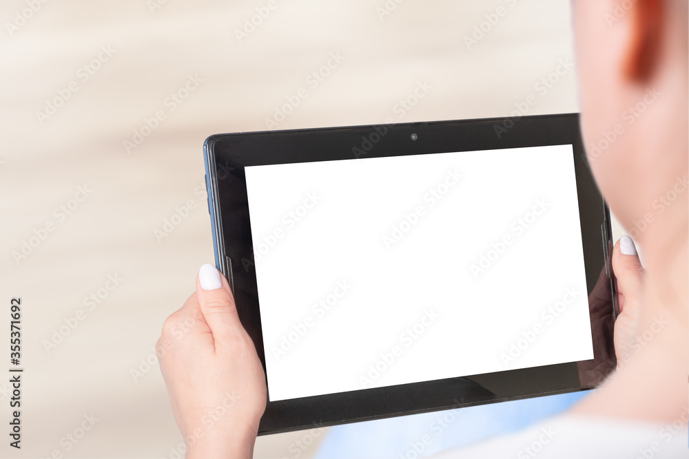 Mockup image of woman's hand holding white tablet pc. Woman sitting and holding white screen mockup tablet