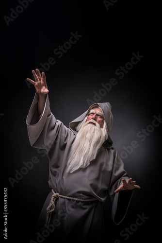 Portrait of a manly and brutal, majestic, old man, sorcerer, wizard with gray hair and a beard with a mustache, in gray clothes, a canopy and tunic
