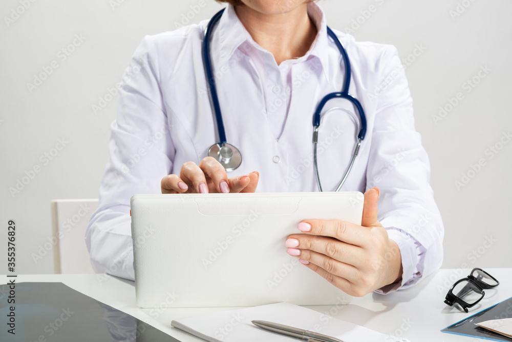 Close up female doctor hands using tablet computer Close up female doctor hands using tablet computer
