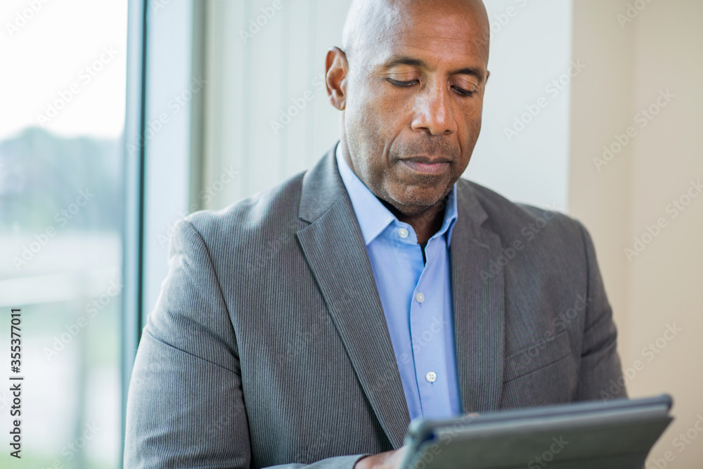 Mature African American man working on a tablet. Mature African American man working on a tablet.