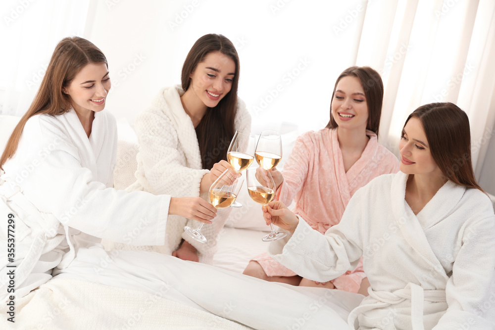 Beautiful young ladies toasting at pamper party indoors. Woman's Day Beautiful young ladies toasting at pamper party indoors. Woman's Day