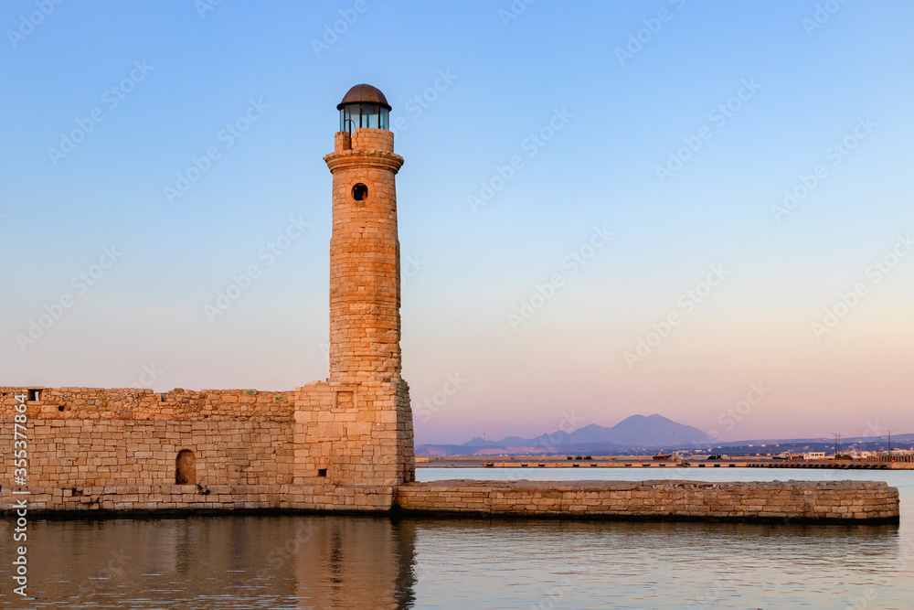 An old lighthouse against the sunset sky. Greece. Crete. Rethymno.
