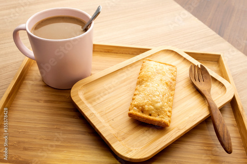 Hot coffee and pies on a wooden tray