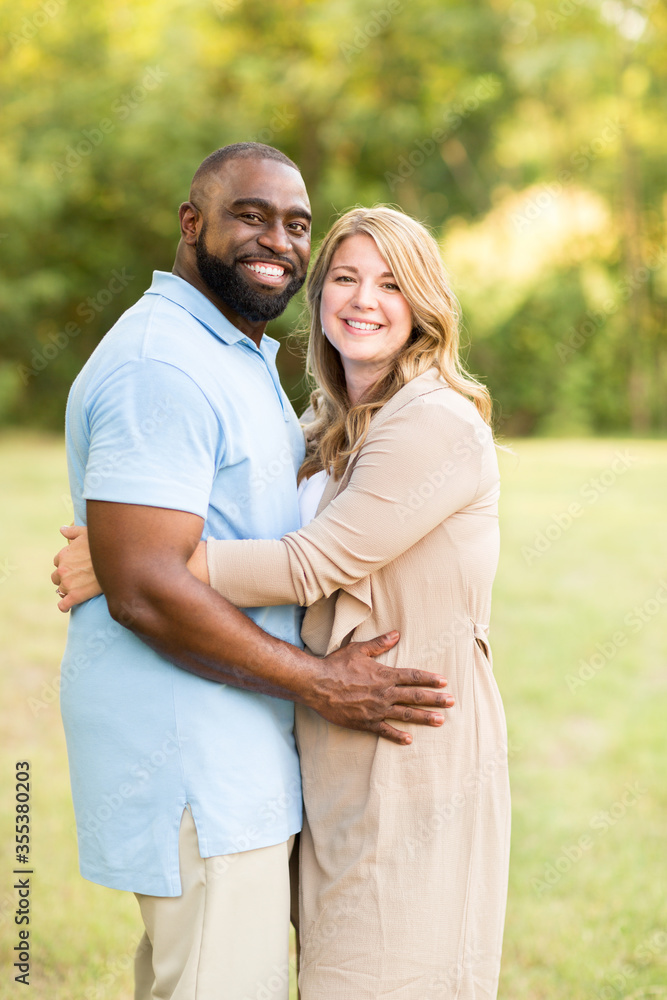 Obraz premium Loving mixed race couple hugging and laughing.