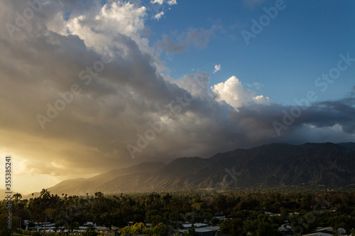 The sun sets behind clouds over the San Gabriel Mountains of Southern California