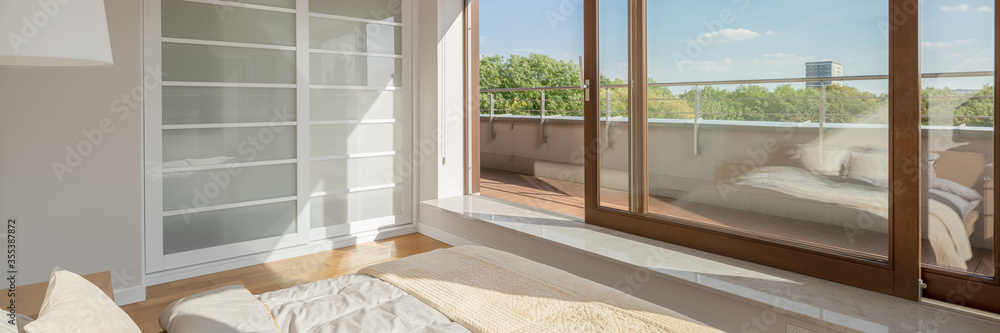 Fototapeta premium Bedroom with window wall and balcony, panorama