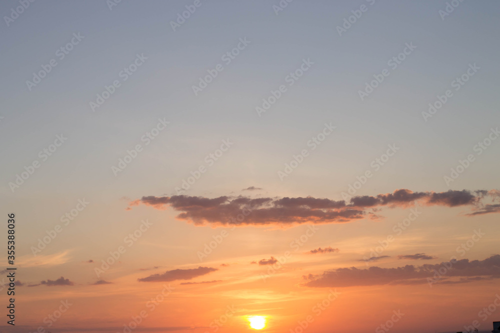 horizonte, puesta de sol con tonos cálidos, fondo oscuro, una ciudad, con nubes oscuras