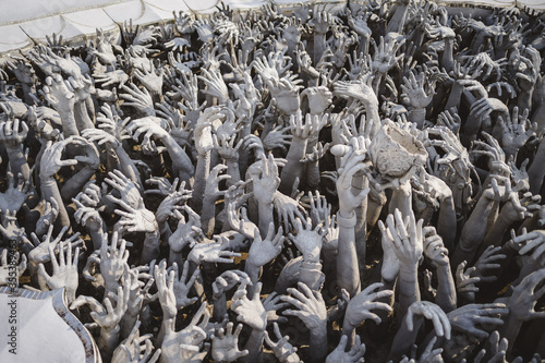 Greifende Hände aus Beton neben Wat Rong Khun weißer Tempel in Chiang Rai, Thailand