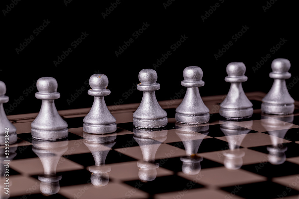 Chess pieces in silver on a black background. Board game chess. Chess pieces in silver on a black background. Board game chess.