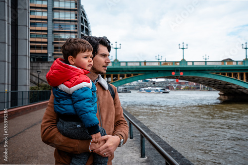 Father and son looking towards the river next to the Southwark Bridge in London