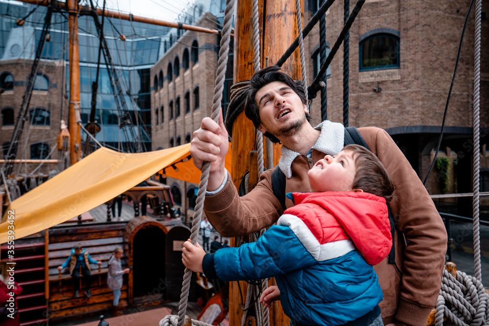 Sailing father and son with a wooden ship