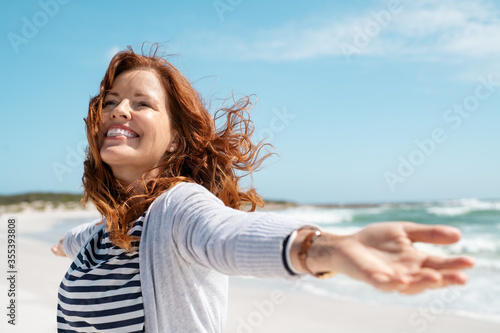 Quadro em tela Mature woman enjoy breeze at beach