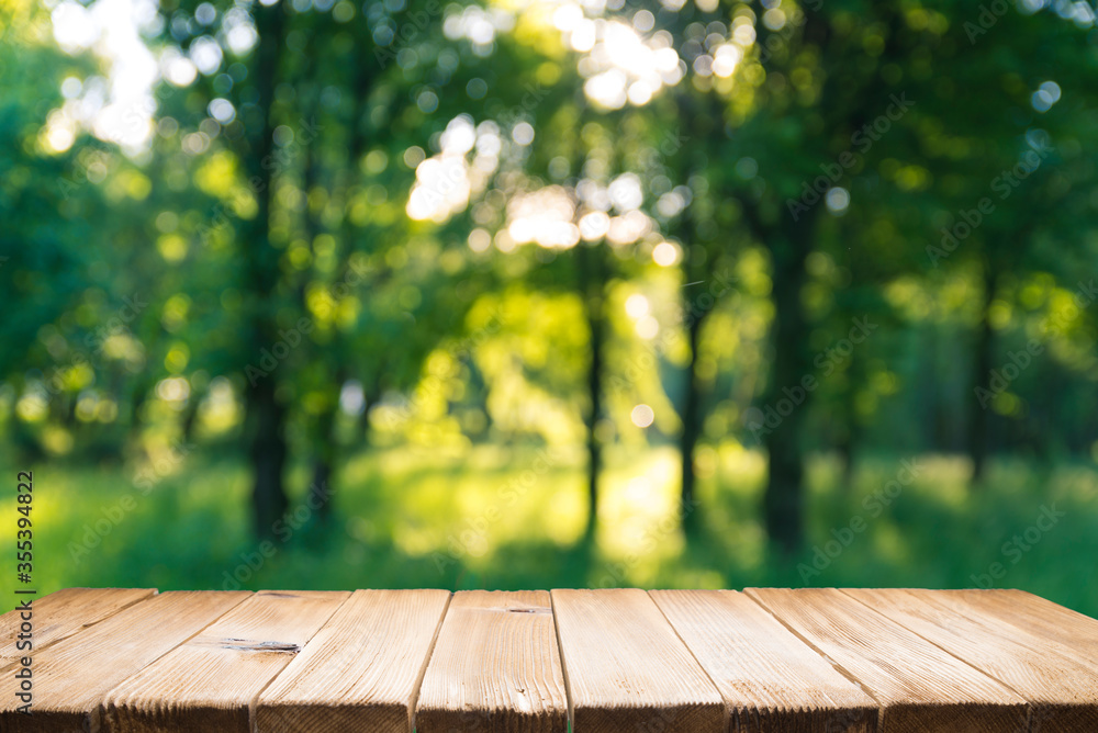 Empty wooden deck table with park bokeh background. - obrazy, fototapety, plakaty 