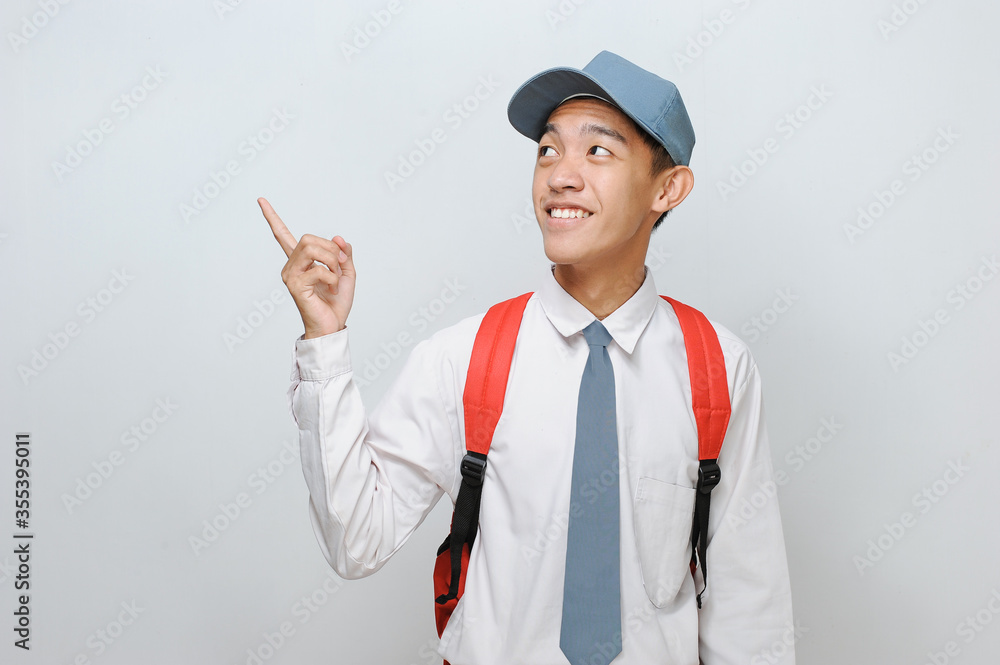 Indonesian Student wearing Senior High School uniform pointing at copy space or blank space Indonesian Student wearing Senior High School uniform pointing at copy space or blank space