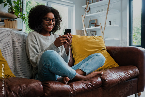 Gorgeous woman texting on smartphone and smiling with joy