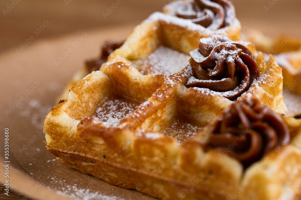 Viennese waffles on a disposable plate with peanut butter, icing sugar and mint. Viennese waffles on a disposable plate with peanut butter, icing sugar and mint.