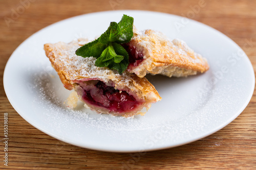 fried pie with cherries, mint and powdered sugar