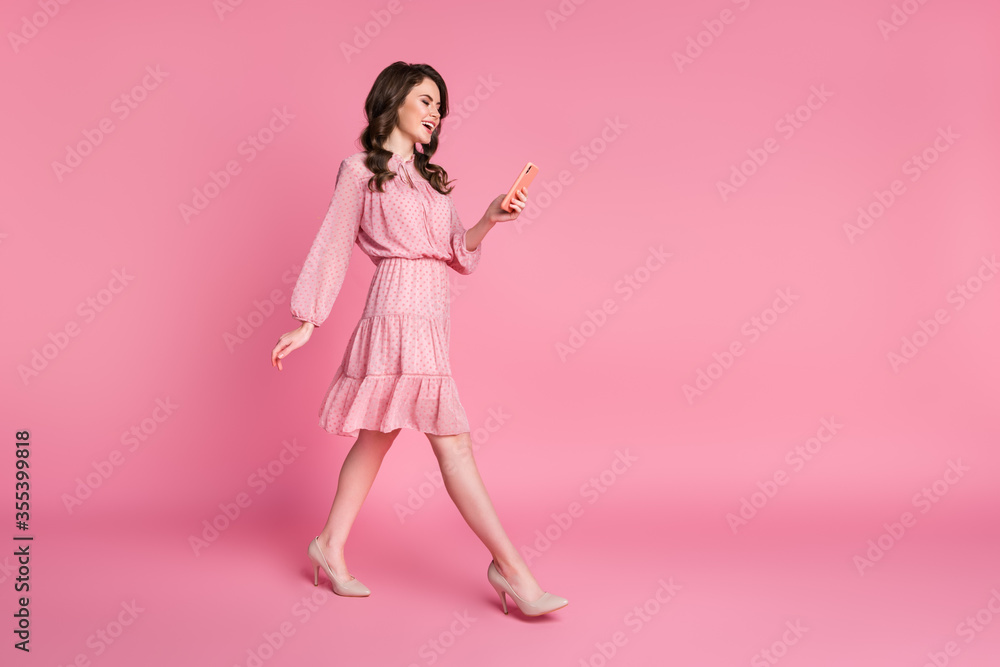 Full length profile side photo of positive cheerful girl go walk free time use smartphone laugh social network feedback wear skirt stilettos isolated pastel color background Full length profile side photo of positive cheerful girl go walk free time use smartphone laugh social network feedback wear skirt stilettos isolated pastel color background