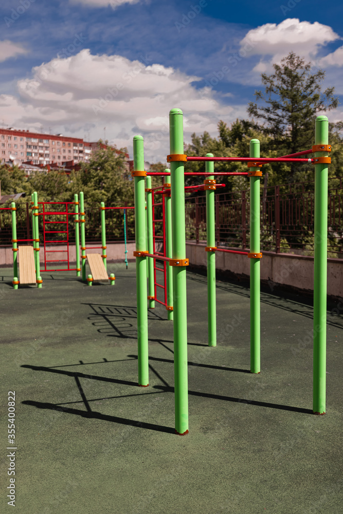 green and red horizontal bars on a playground in the summer
green and red horizontal bars on a playground in the summer