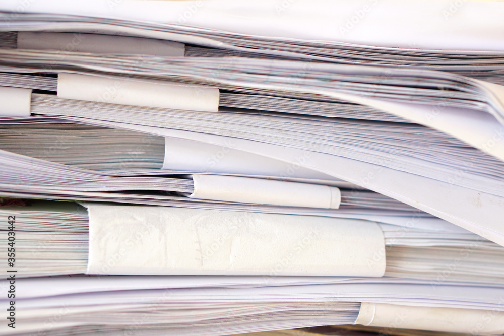 Stack of business report paper files on desk Stack of business report paper files on desk