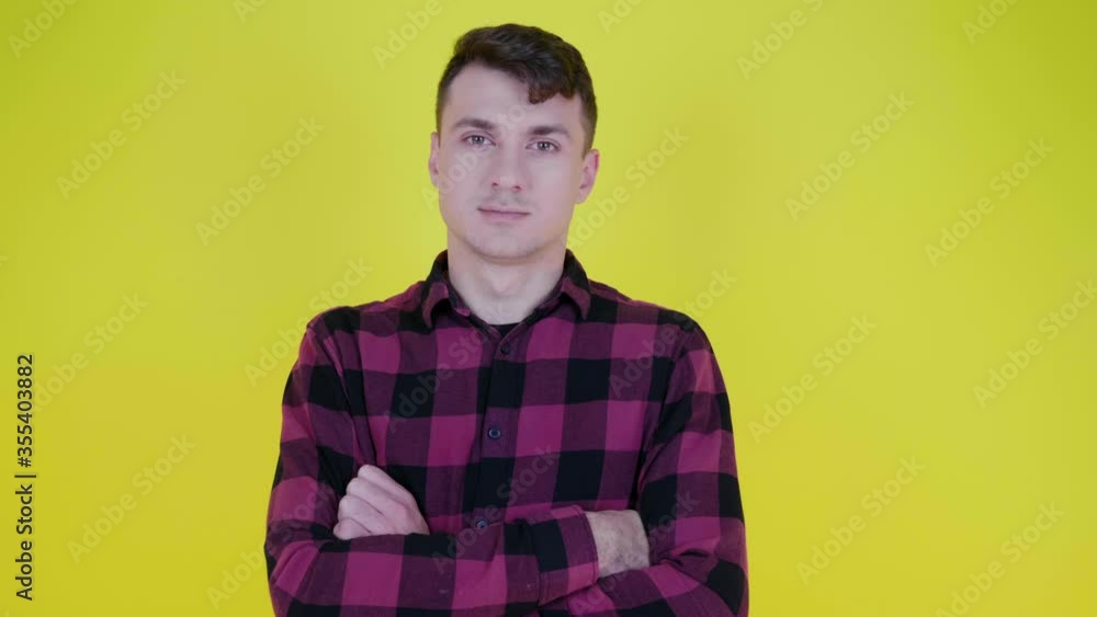 custom made wallpaper toronto digitalSerious man in a pink plaid shirt turns to the camera and crosses his arms on his stomach on a yellow background with copy space. Place for text or product. 4K slow motion footage