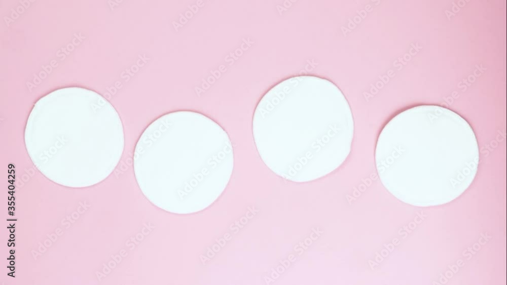 organic cotton pads moving on pink background. Zero waste, reusable, eco, makeup remover and washing concept. pattern, hard light, stop motion animation. organic cotton pads moving on pink background. Zero waste, reusable, eco, makeup remover and washing concept. pattern, hard light, stop motion animation.