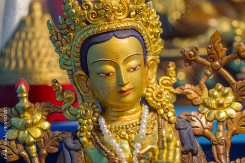 Close up of Golden statue showing buddhist deity Tara at a temple. photo