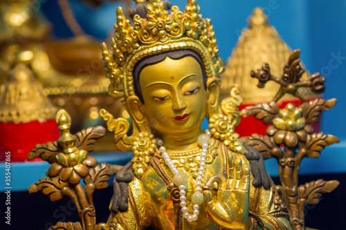 Golden statue showing buddhist deity Tara at a temple.