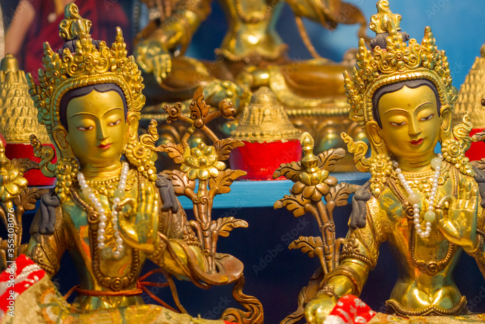 Golden statues showing different buddhist deity Tara at a temple.