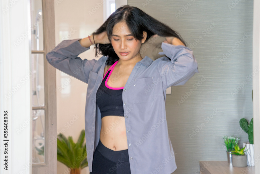 Fototapeta premium Beautiful women in sportswear wear shirts to prepare to work at home.