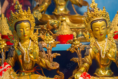 Golden statues showing different buddhist deity Tara at a temple.