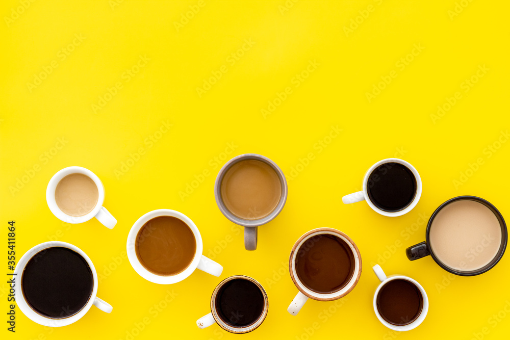 Cups of hot drinks on yellow table top-down space for text Cups of hot drinks on yellow table top-down space for text