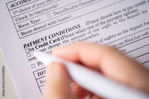 Bilde på lerret Woman customer filling hotel reservation form on the table at the office, payment conditionsby credit card