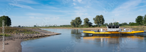 yellow ferry on river ijssel between olburgen and dieren in gelderland photo