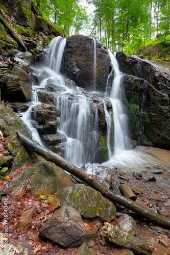 Fototapeta Naklejka Na Ścianę i Meble -  rocks in waterfall stream. beautiful nature scenery in forest. cascade of rapid mountain river. lush green foliage. mossy boulders