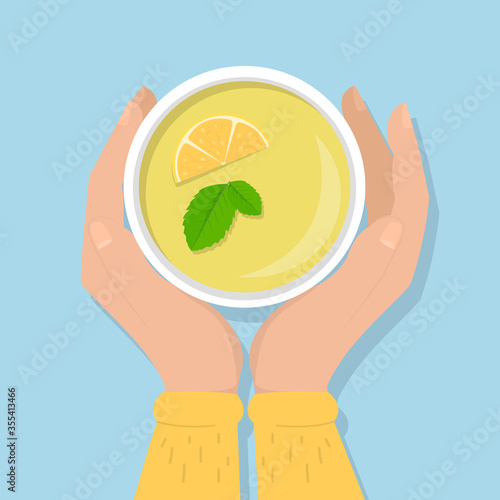 Hands holding cup of green tea with lemon