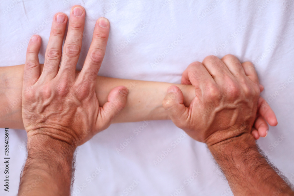 Fototapeta premium Shiatsu massage. Close up of massagers hands working on patients hand and forearm.